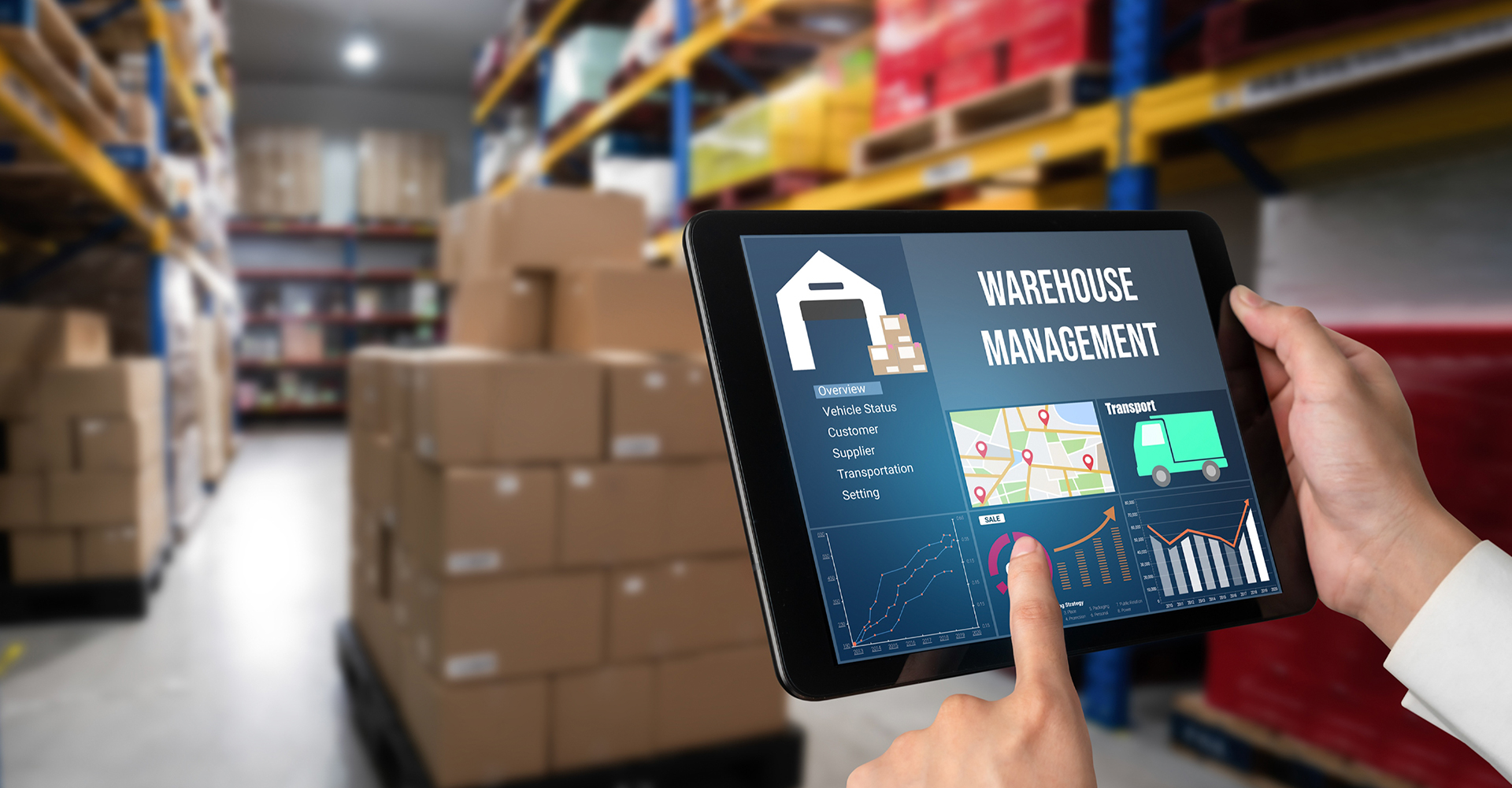 Warehouse operator using a tablet beside storage racks